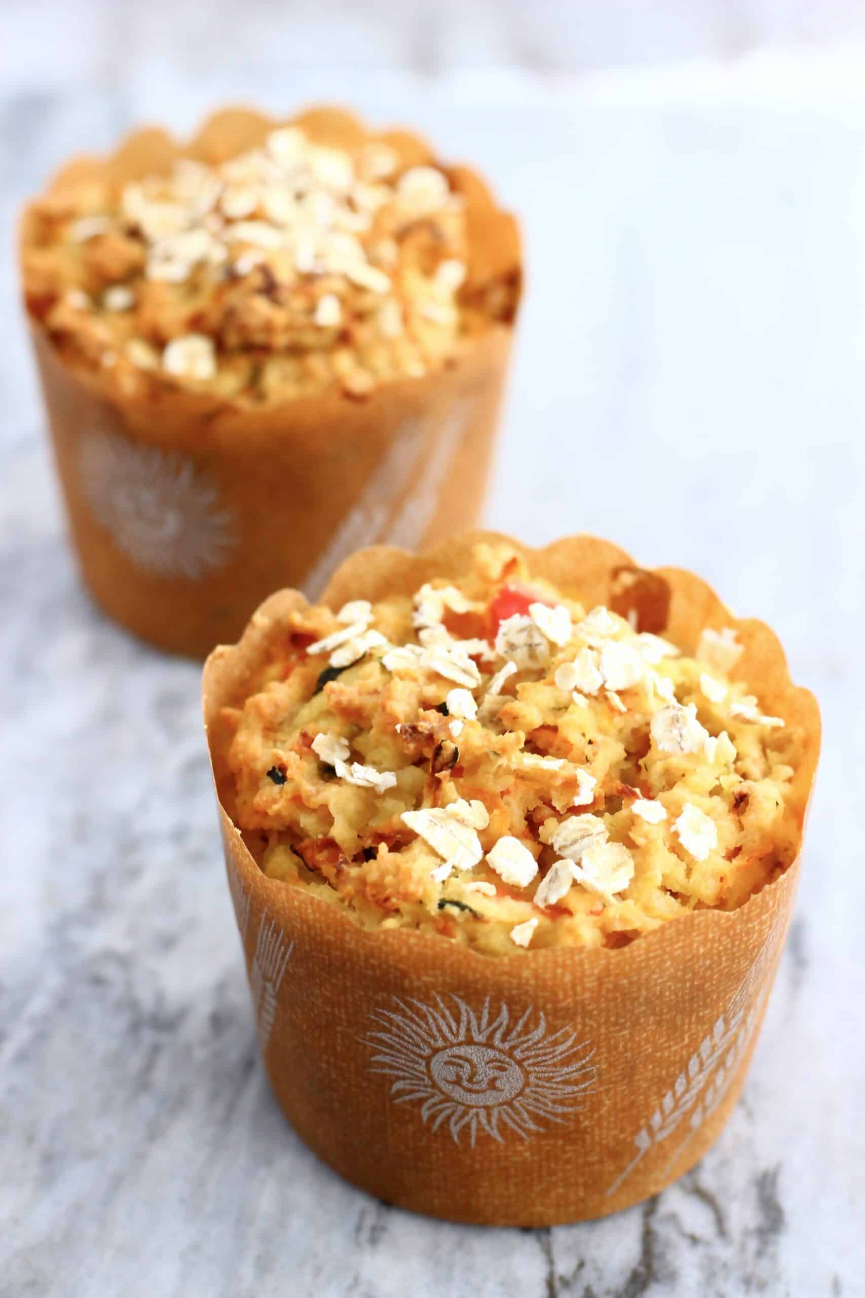 Two gluten-free vegan savoury vegetable muffins on a marble background