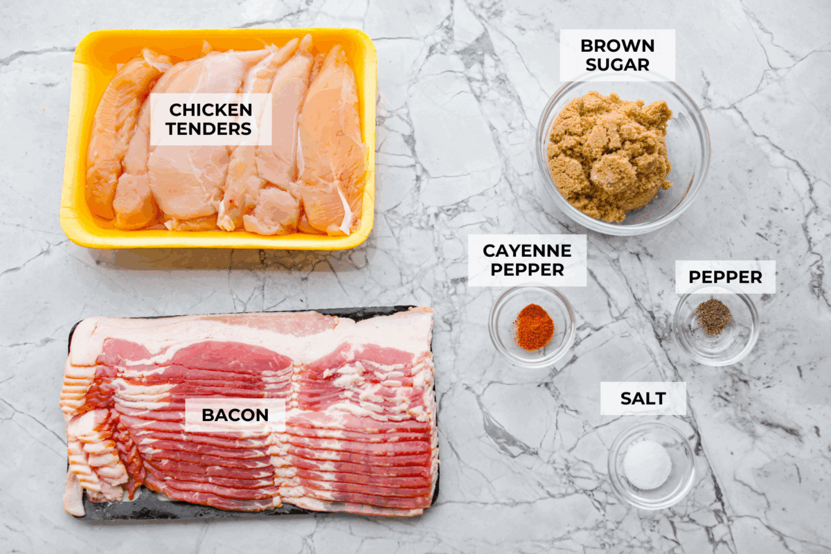Bacon brown sugar chicken tenders are sweet, smoky, and slightly spicy. Made with only a few simple ingredients, they're like candied bacon hugging juicy chicken without being overly sweet. Great as a main or appetizer, and always a total hit! Overhead shot of labeled ingredients.