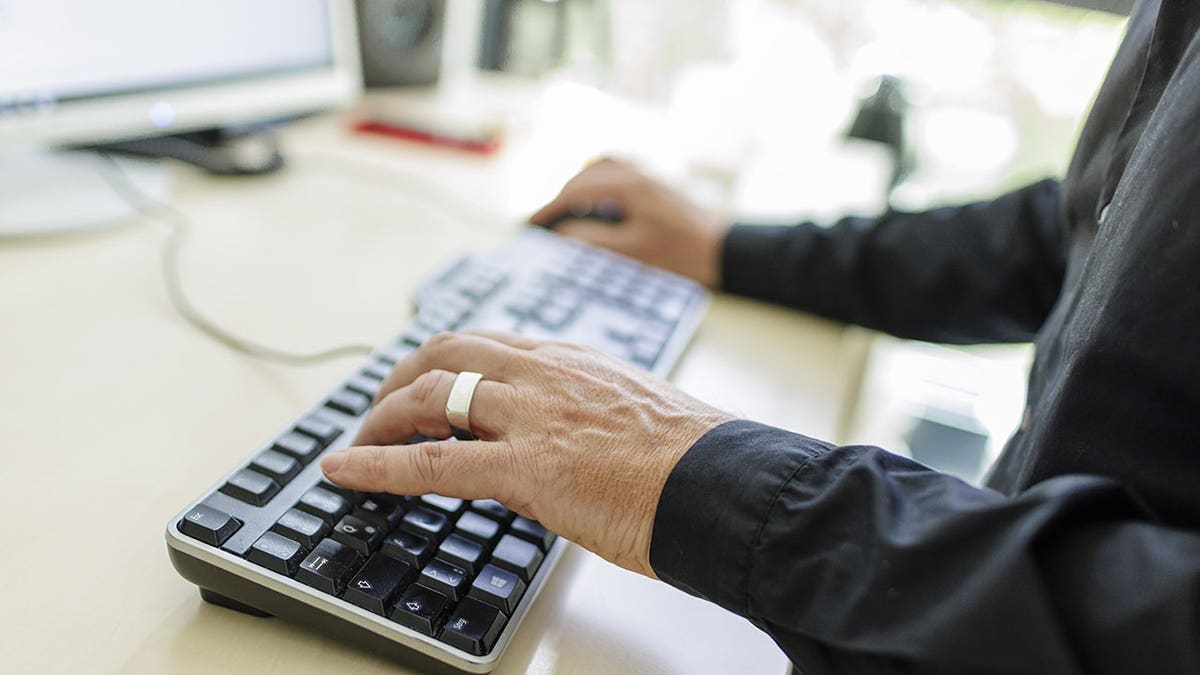 Person typing on their desktop computer.