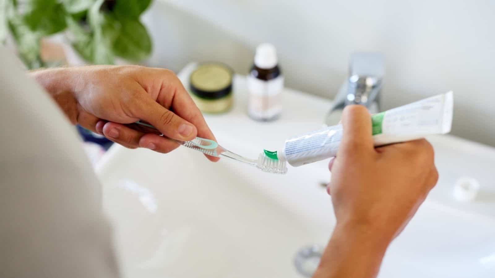 Man squeezing out toothpaste onto toothbrush