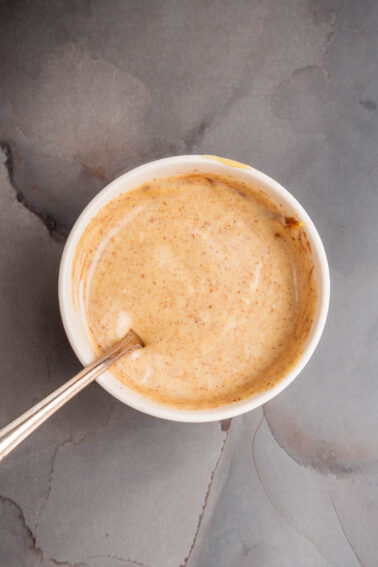 A bowl of maple aioli with a spoon in it.