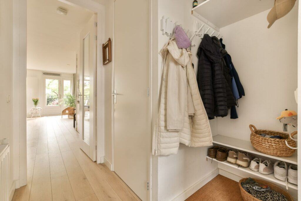 Organised hallway with coat hooks, shoe storage and baskets in a family home.