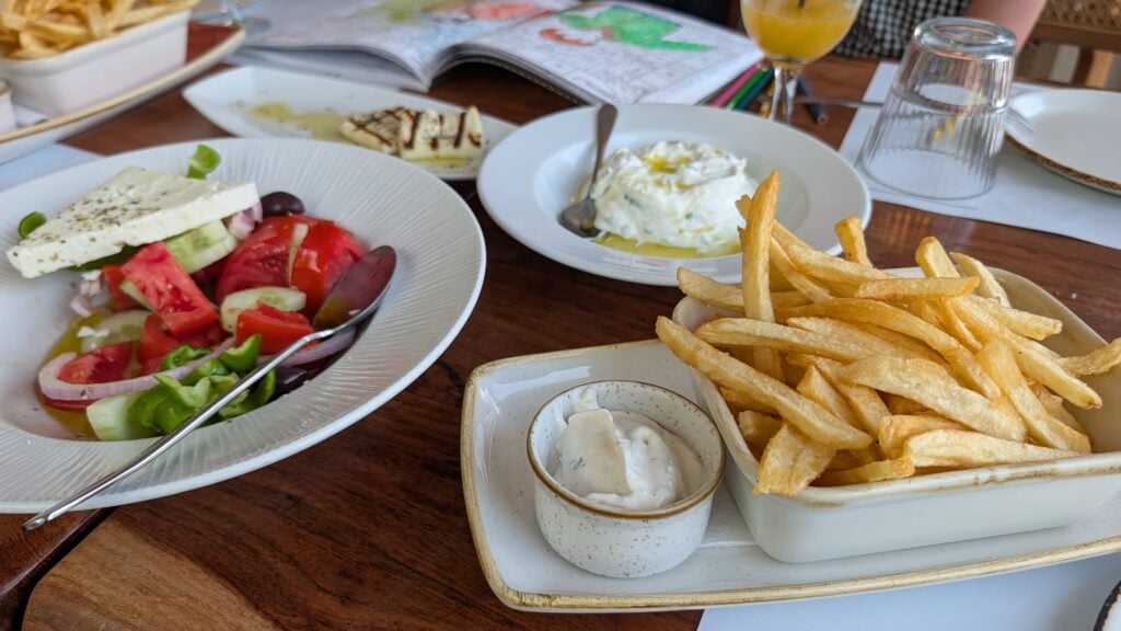 gluten free corfu restaurant avli a table of dishes containing greek salad, tzatziki, halloumi and fries
