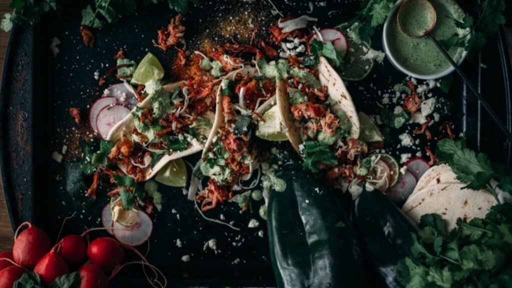 Overhead shot of tacos drizzled with roasted poblano crema. 