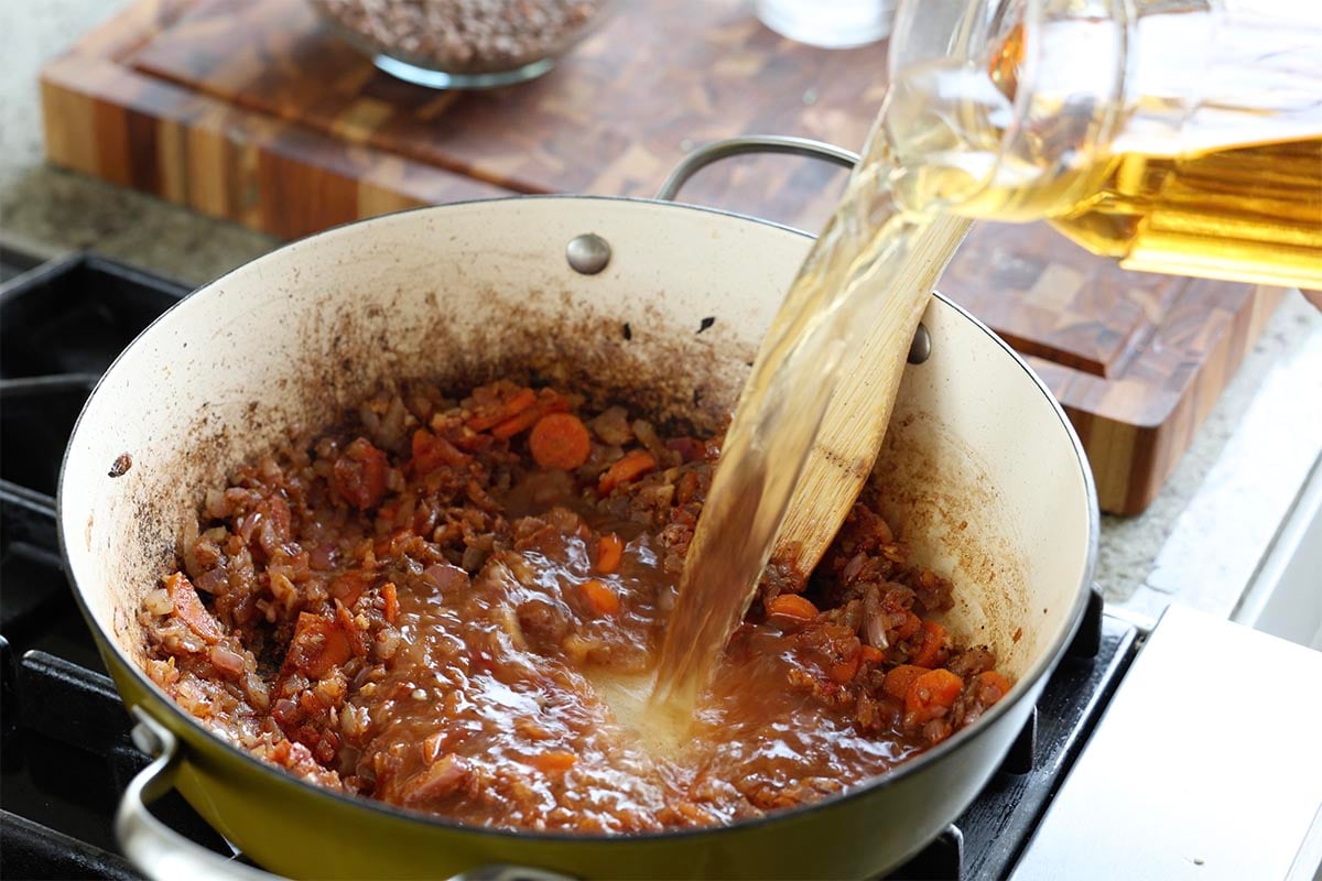 adding veggie broth to the pan