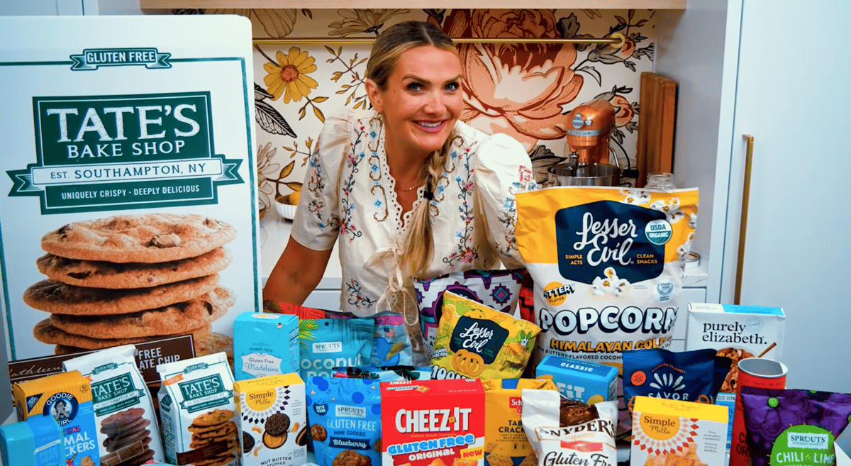 25+ gluten free snacks on a counter with a girl looking at them
