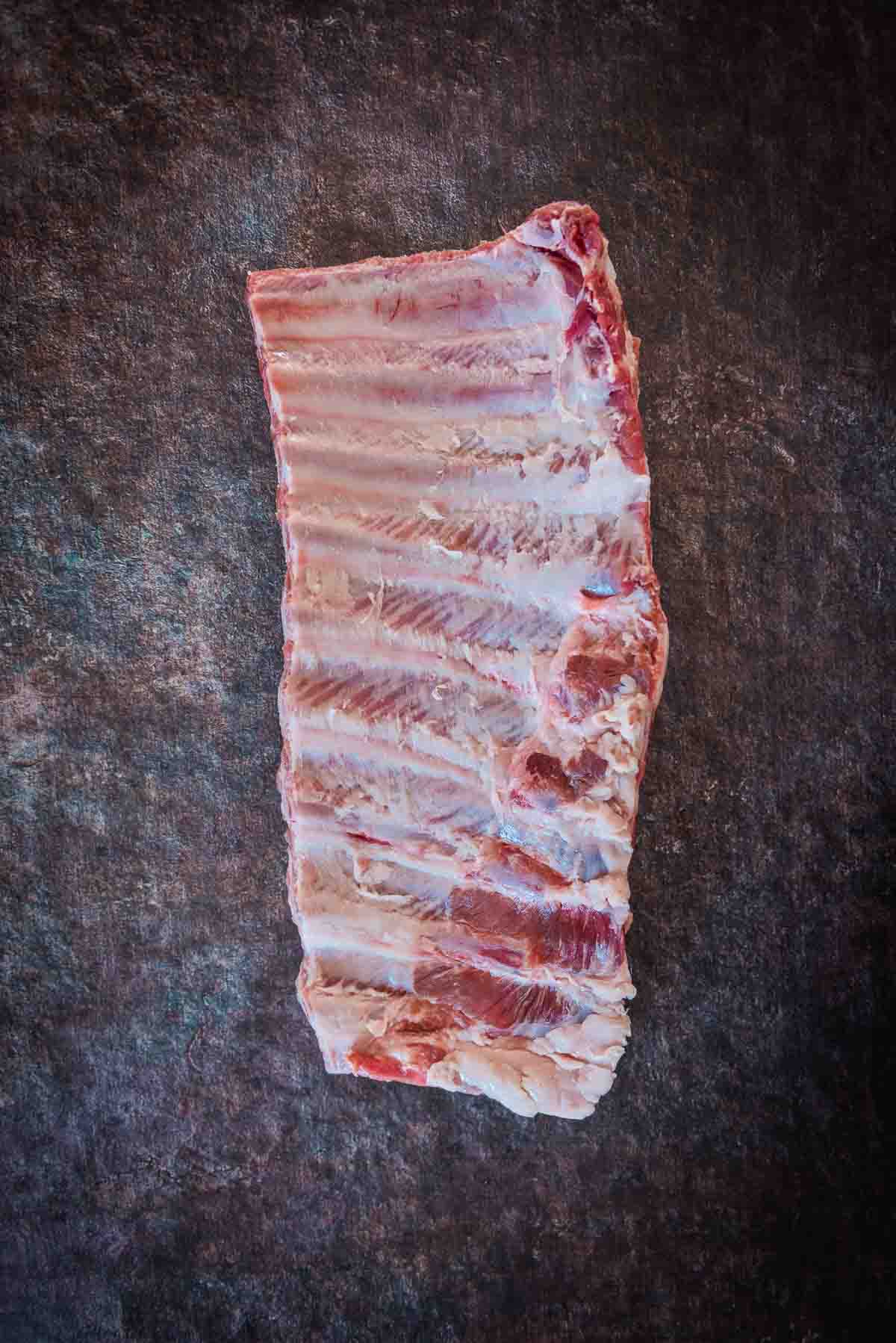 Bone side of a full spare rib rack showing membrane removed.