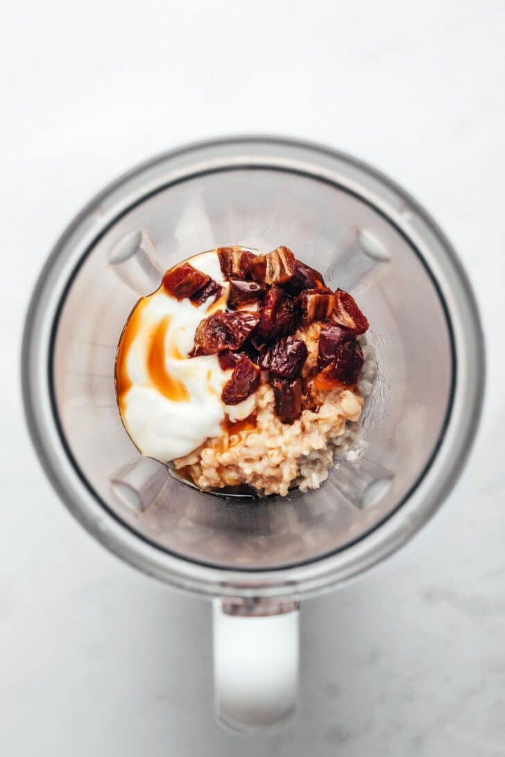 Cooked oats, yogurt, chopped dates, and maple syrup in a blender.