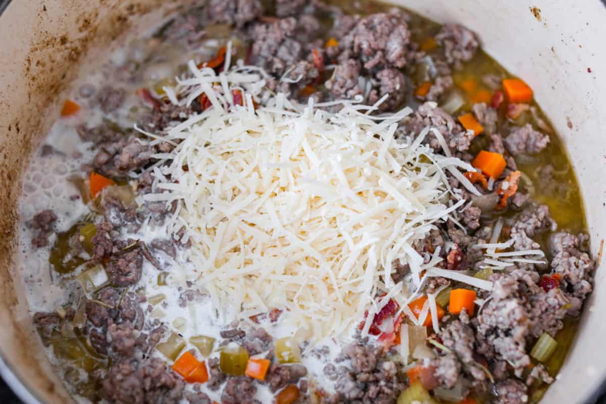 No tomatoes, no red sauce, just a rich, savory white bolognese loaded with beef, pork, bacon, white wine, and plenty of Parmesan. Tossed with noodles, it’s a fun and seriously delicious twist on classic Bolognese. Cheese and cream added to the meat and veggie mixture.