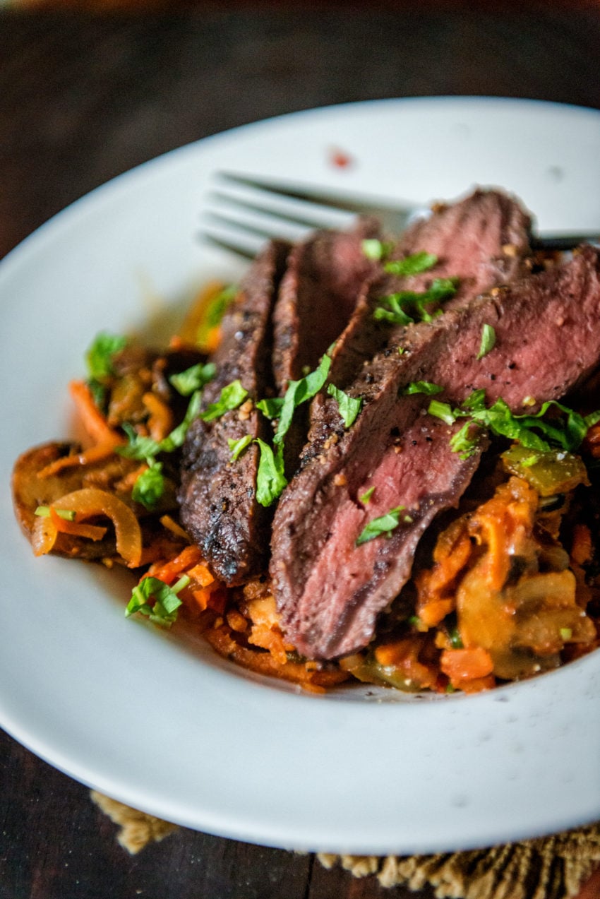Sliced flat iron steak over marinara tossed veggie noodles.