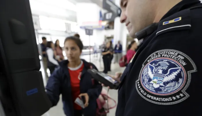 U.S. Customs and Border Protection officer Julio Corro, right, helps a passenger navigate one of the new facial recognition kiosks at a United Airlines gate before boarding a flight to Tokyo, Wednesday, July 12, 2017, at George Bush Intercontinental Airport, in Houston. 