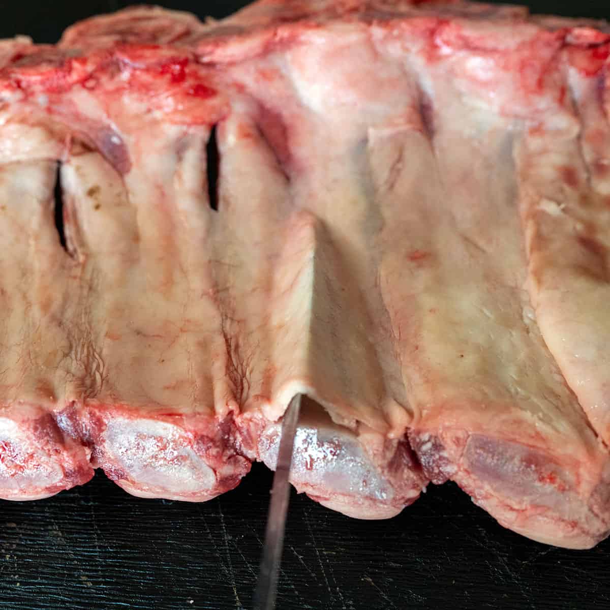 knife slid under membrane of beef back ribs.