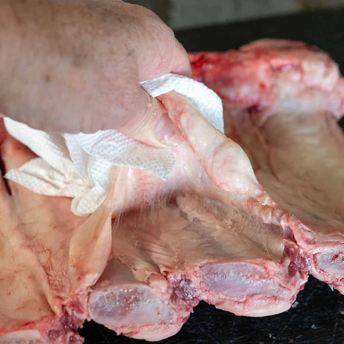 using paper towel to remove membrane on beef back ribs.