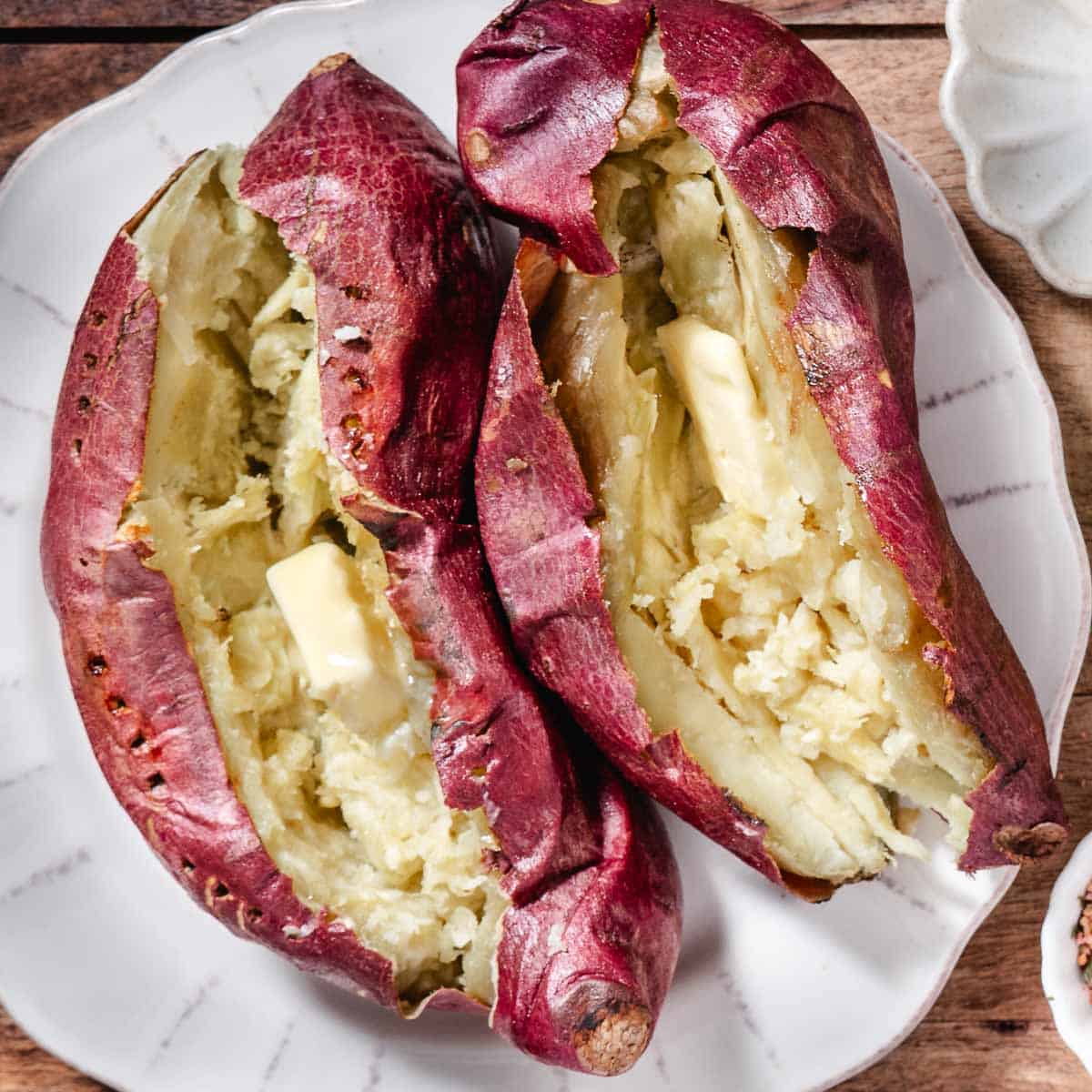 Baked Japanese sweet potatoes split open with melting butter