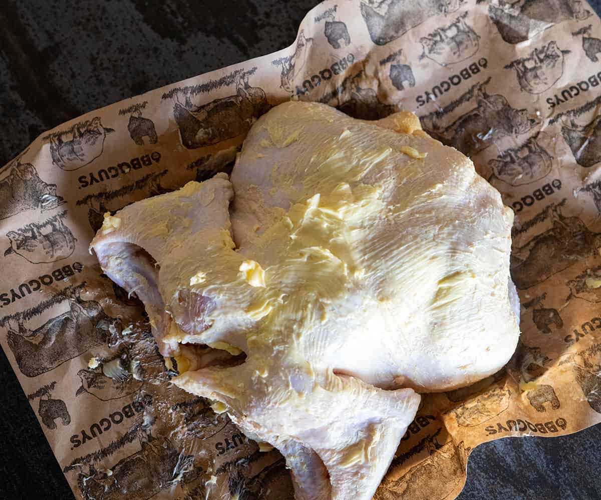 whole chicken rubbed with butter.