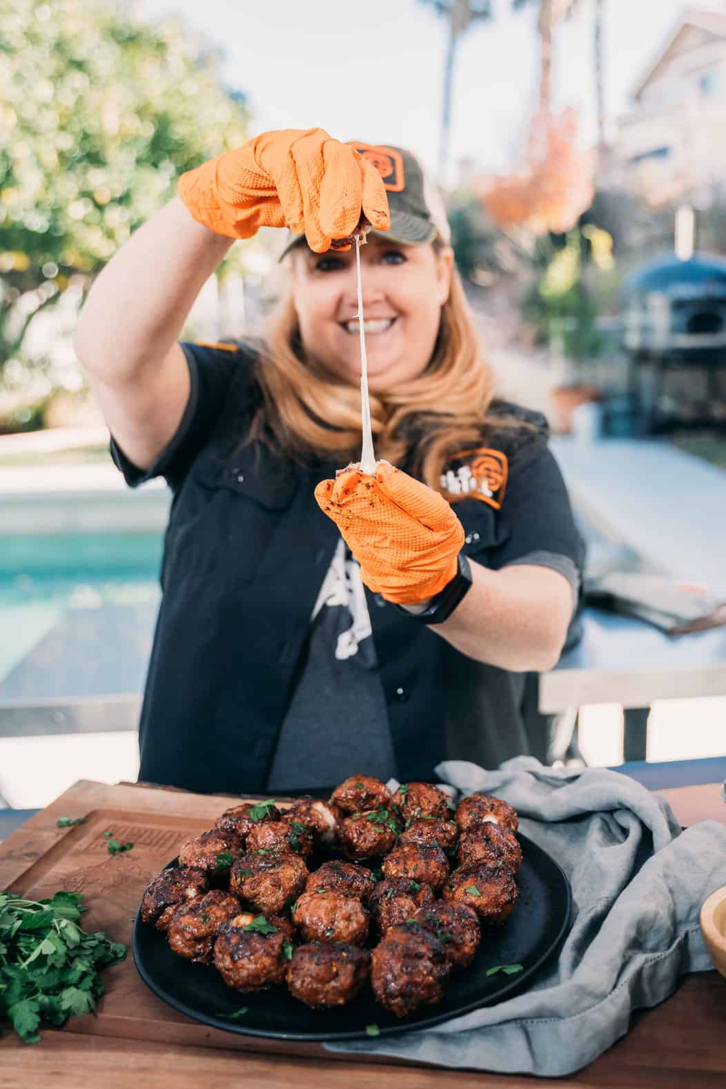 woman stretching meatball to reveal cheese.