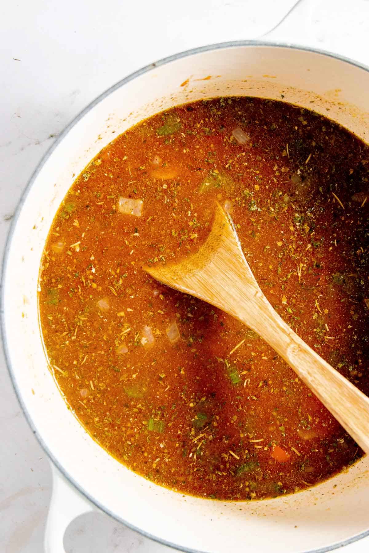 A pot of soup with a wooden spoon in it.