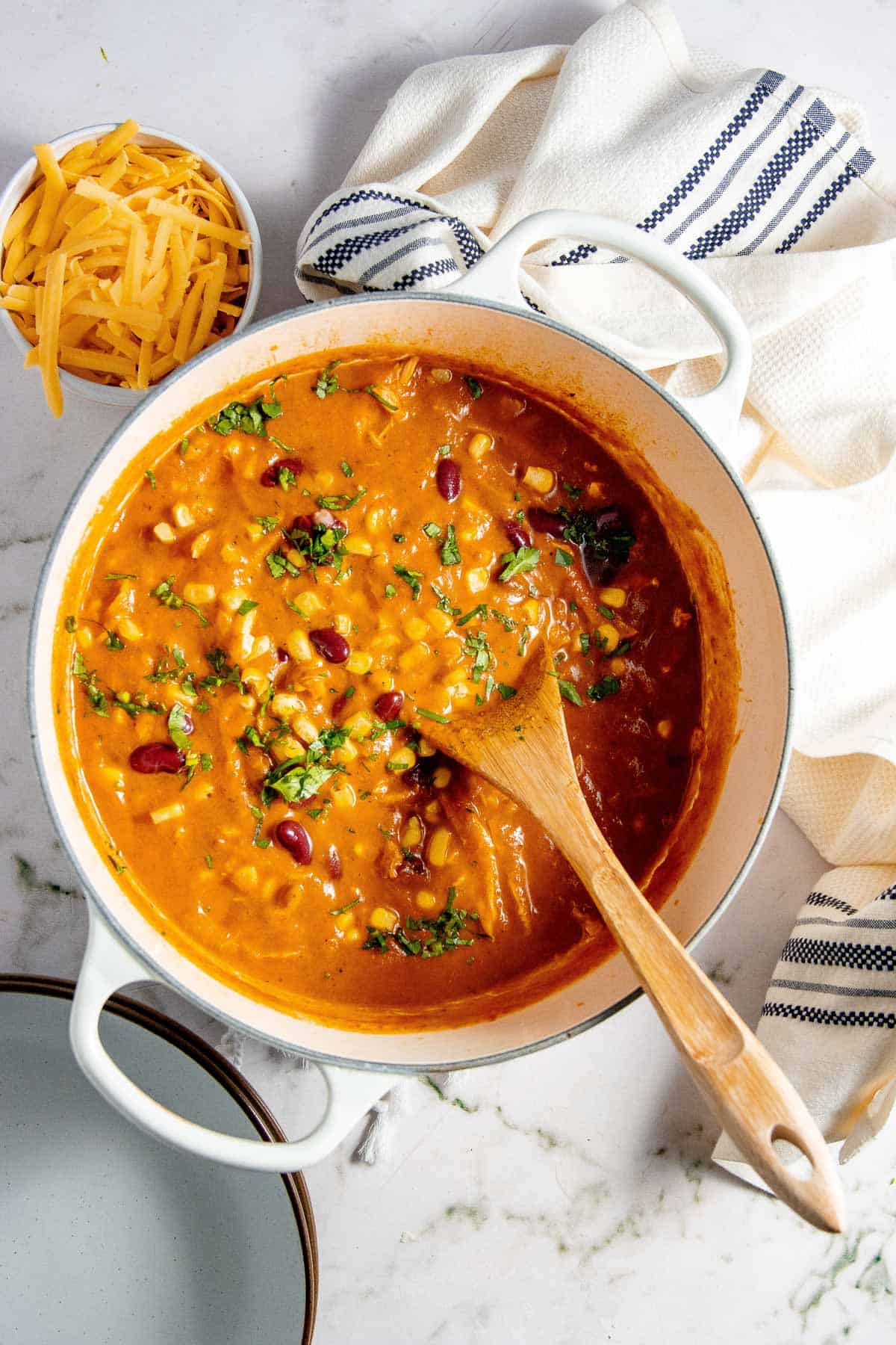 Soup in a pot with a wooden spoon.