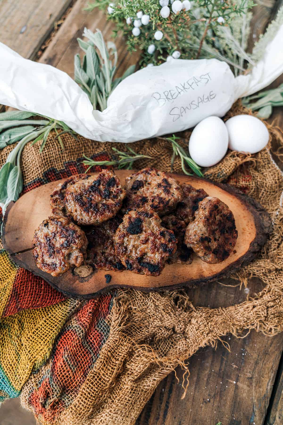 cooked sausage patties on a wood plate.