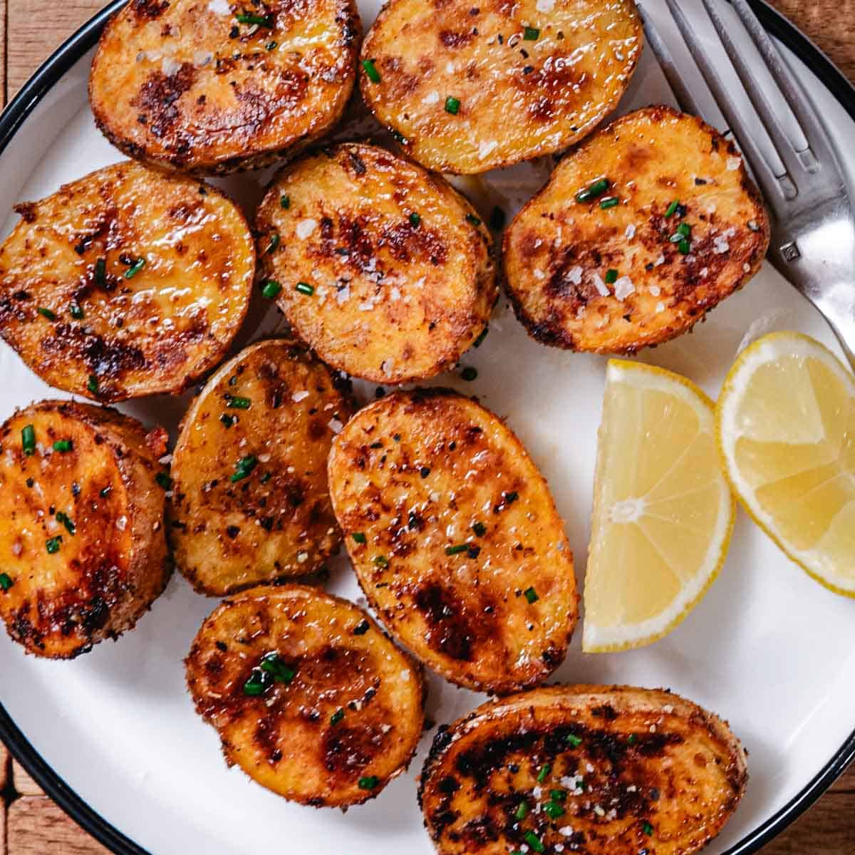 Crispy roasted baby potatoes seasoned with herbs on a white serving plate