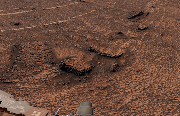 A photo of the Martian surface with polygon-shaped rock formations on the surface.