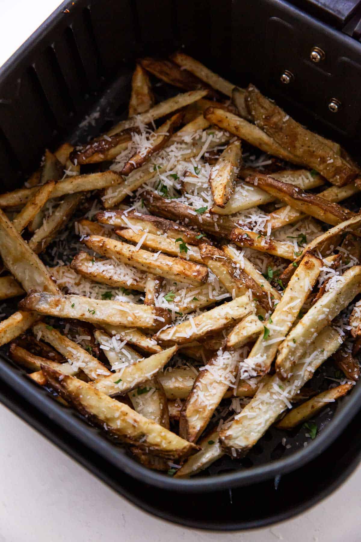 Pile of french fries in the air fryer.