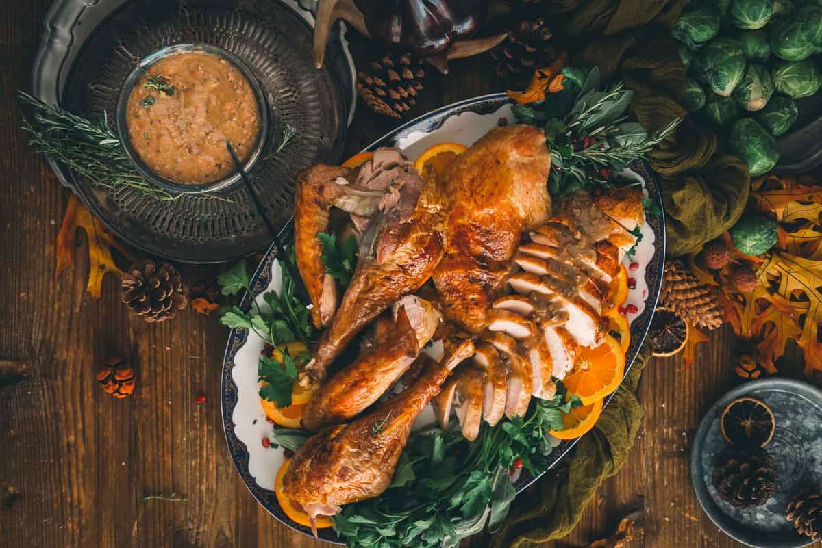 Turkey plated for serving and gravy on the side in a bowl.