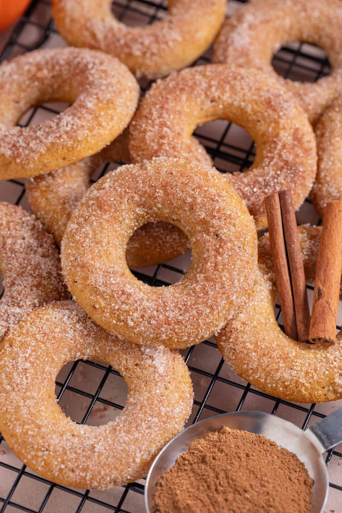 Close up of a pile of pumpkin donuts with cinnamon sugar.