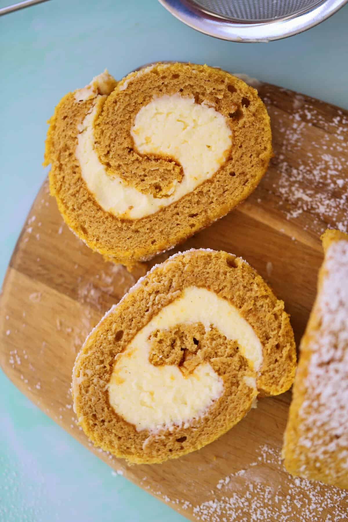 Slices of gluten free pumpkin roll on a wooden board.