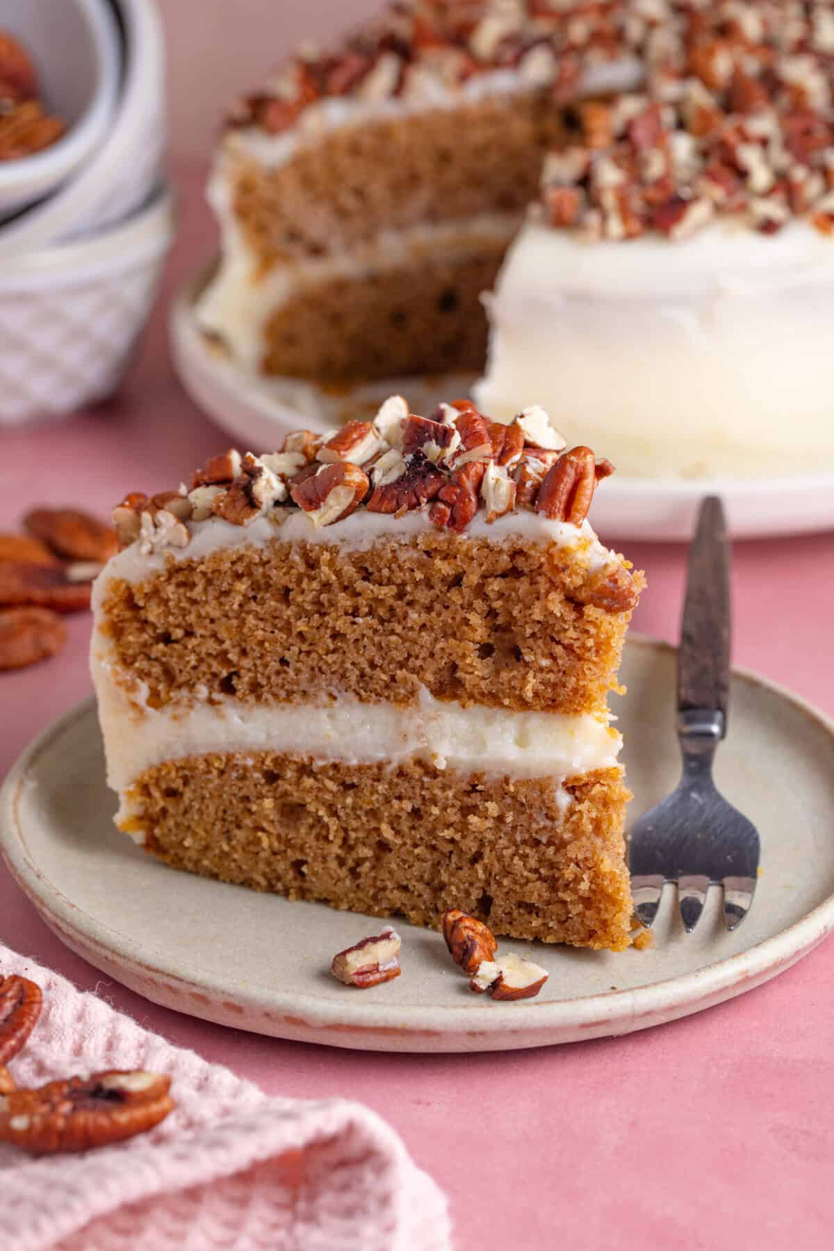 A slice of gluten free pumpkin spice latte cake topped with pecans.