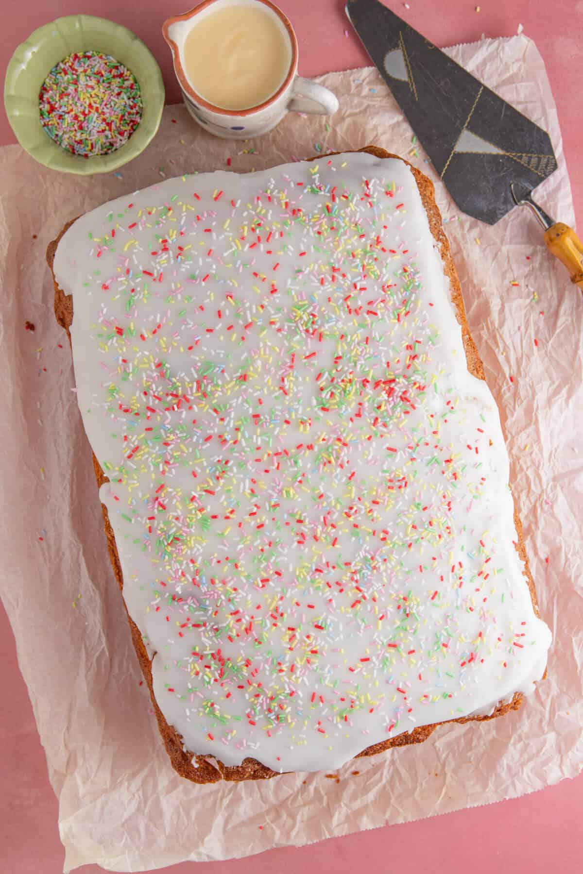 Process shot for gluten free school dinner cake showing the cooled cake coated in icing.