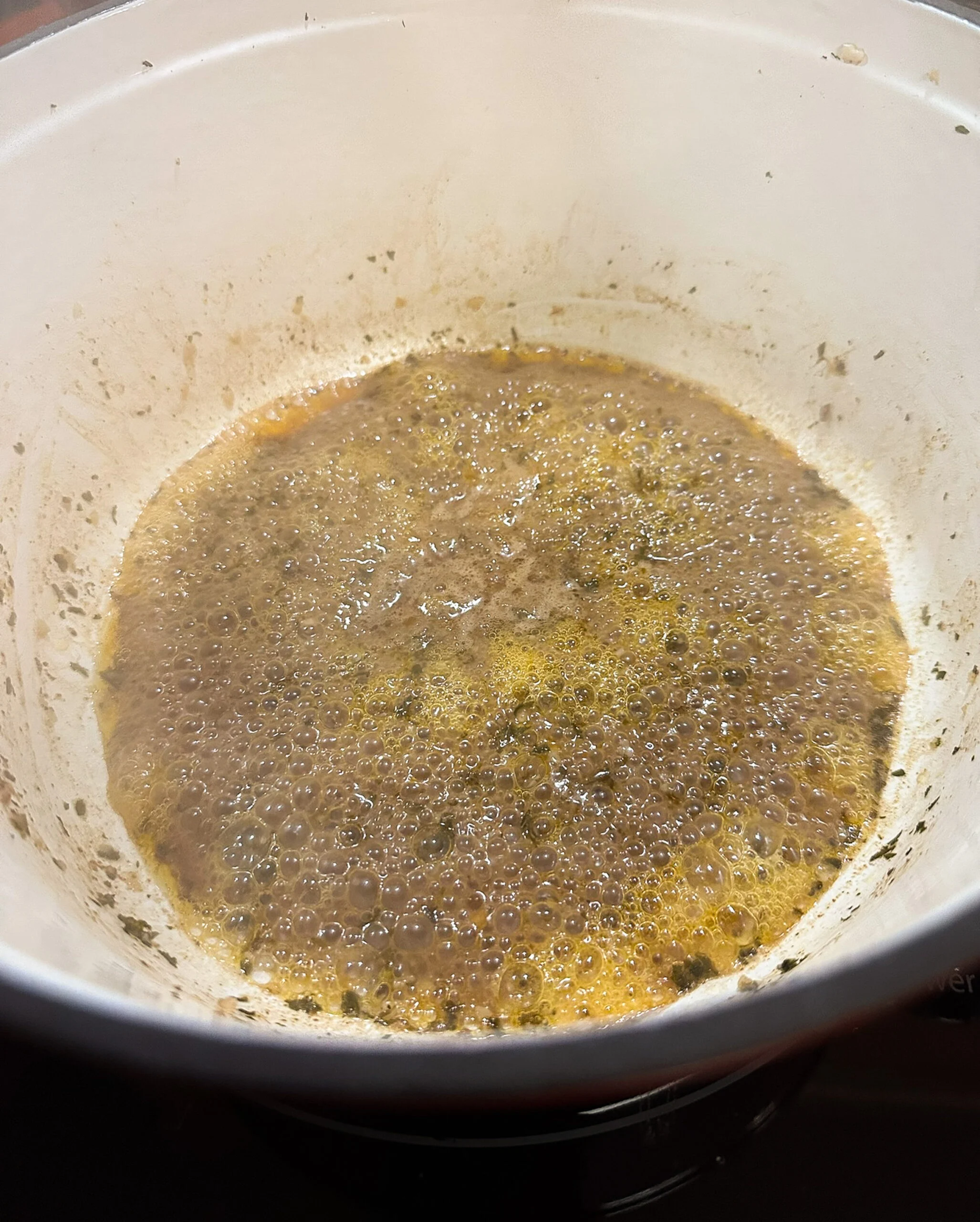Garlicky beef pan juices in an enameled Dutch oven.