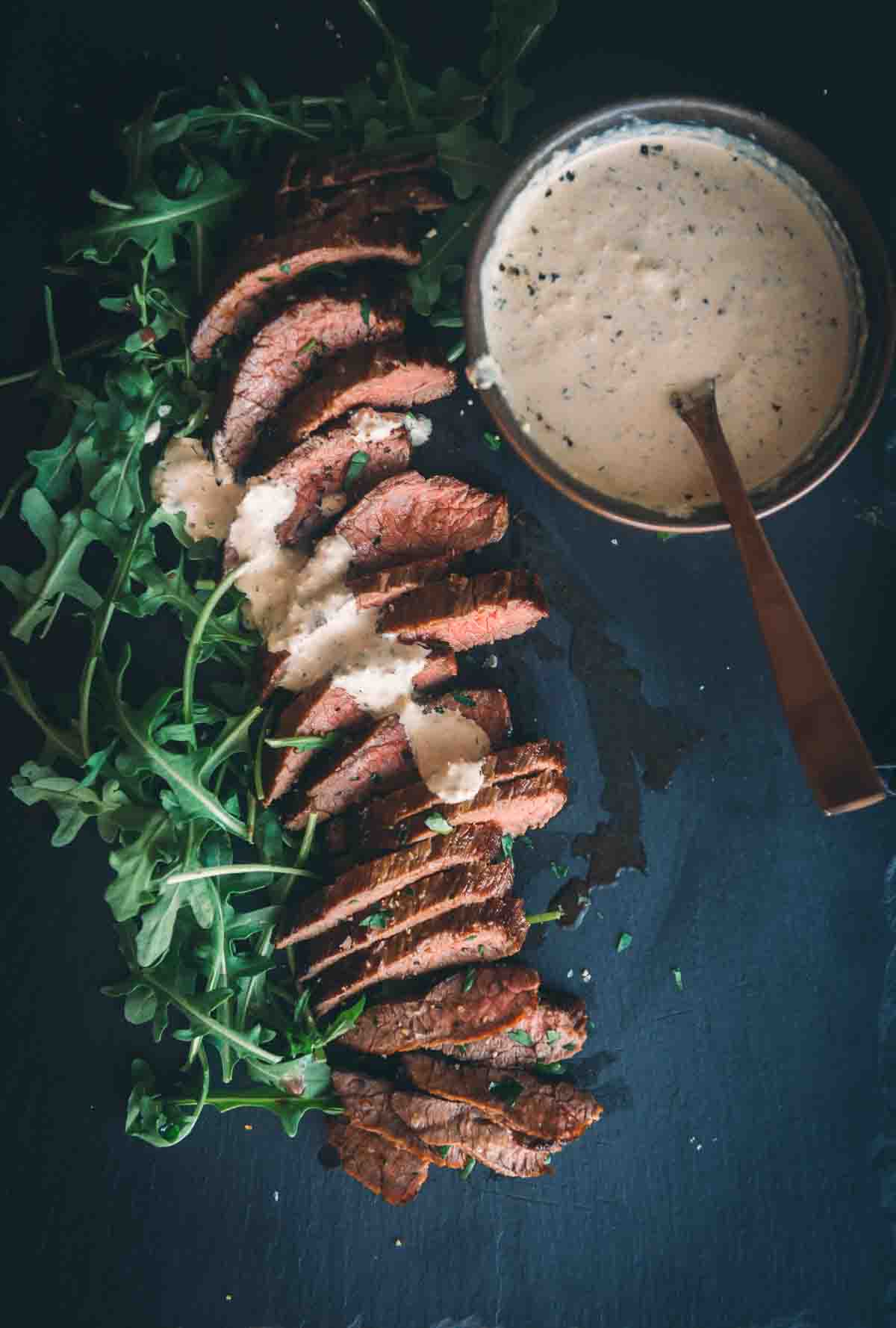 A plate of steak with a sauce on it.