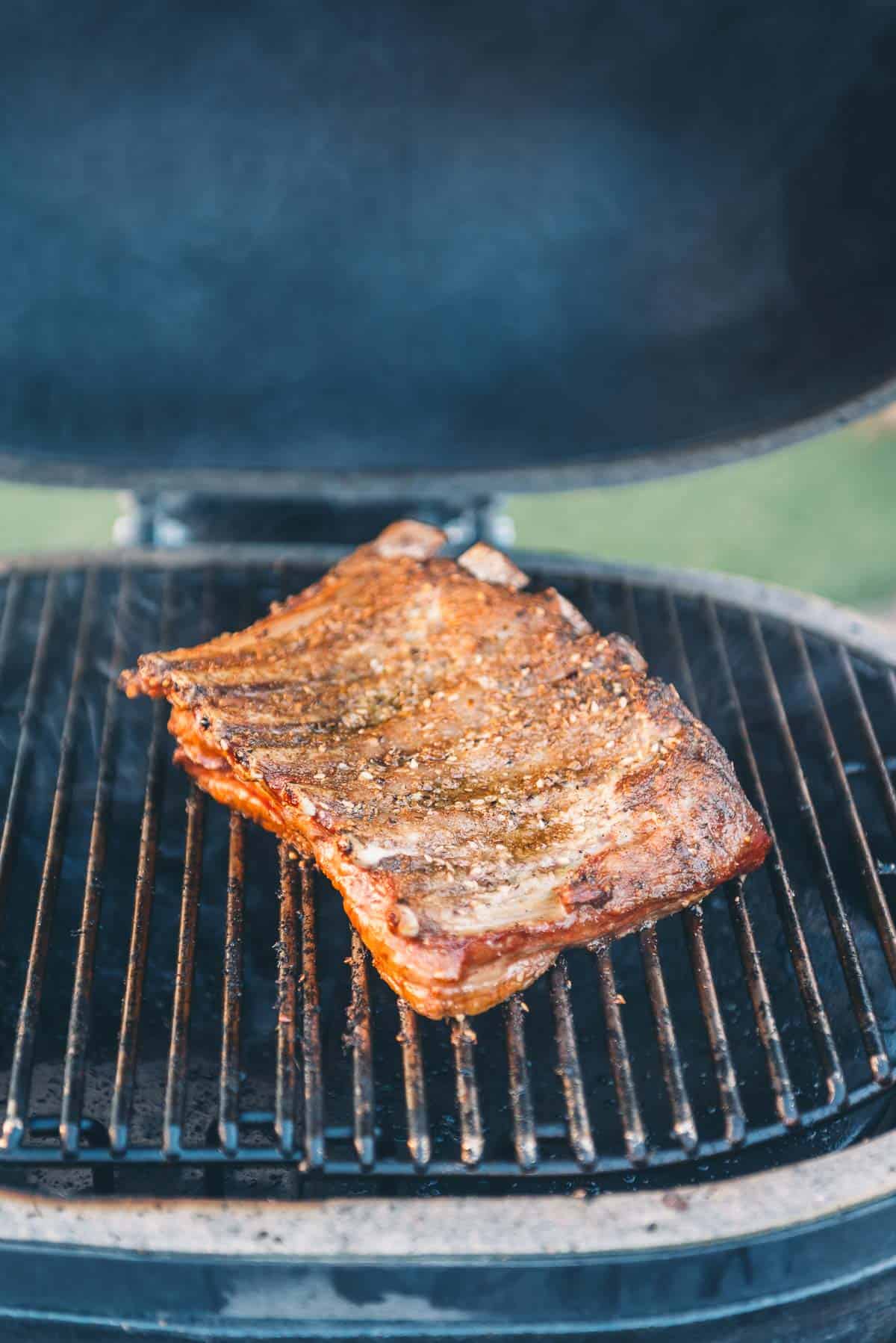 Lamb ribs on the grill after cooking, rib bones peeking through.