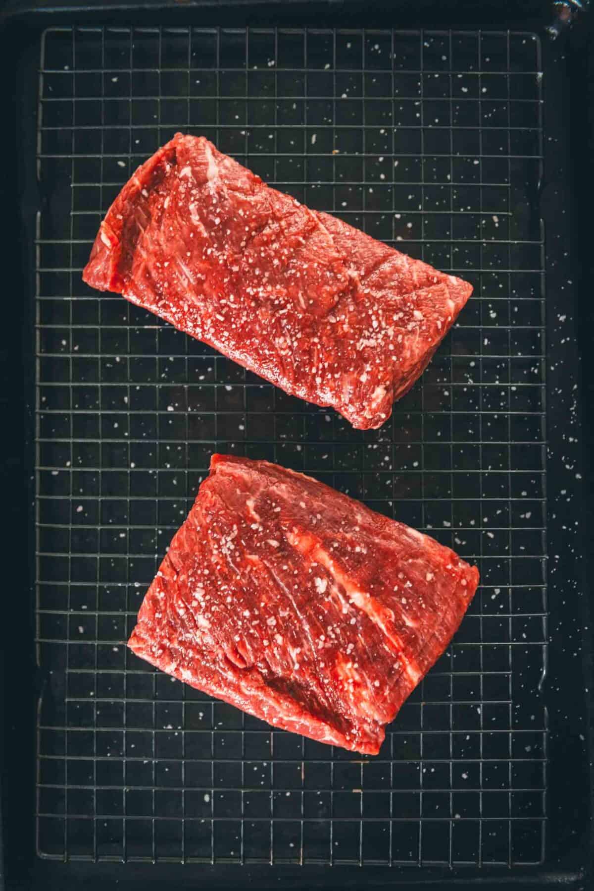 Blade steaks salted and sitting on a wire rack to air dry.