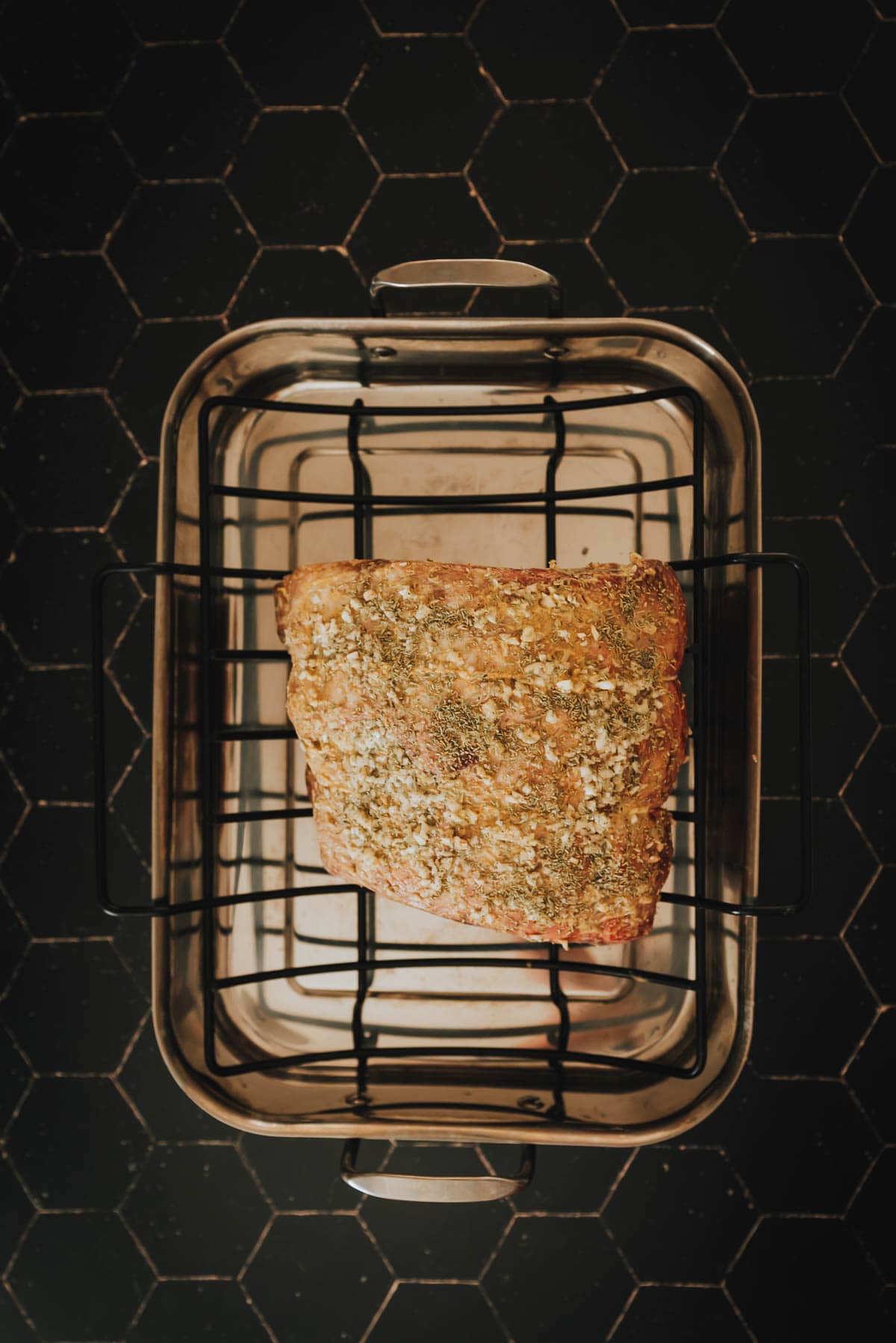 A prime rib is sitting in a metal basket.