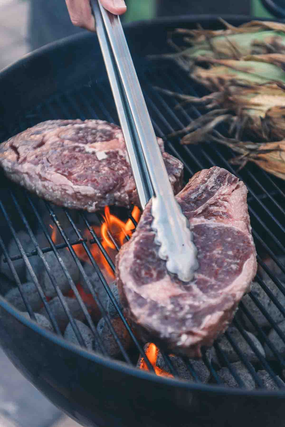 Steaks on the grill grates. 