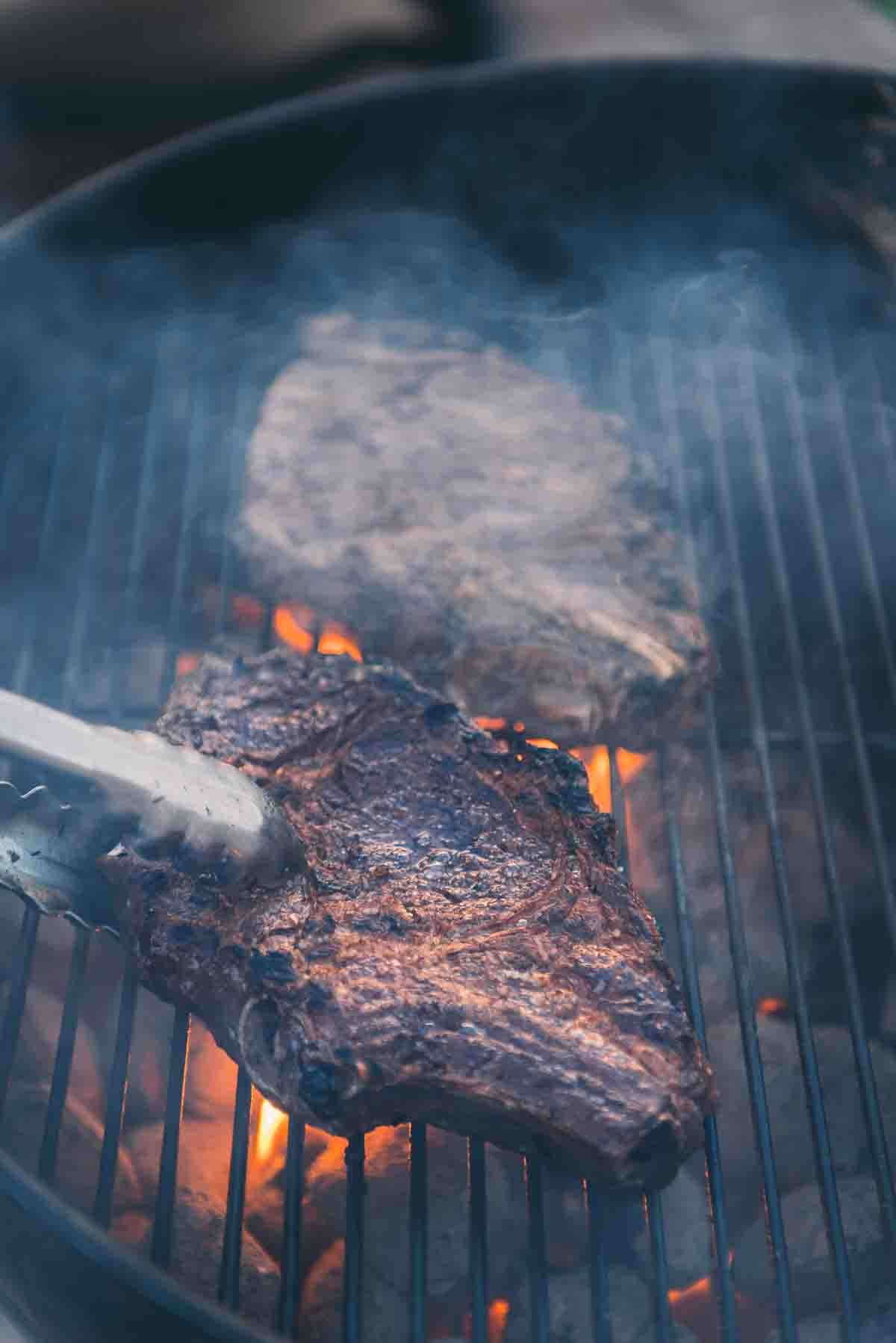 Steaks kissed by flames as they are flipped. 