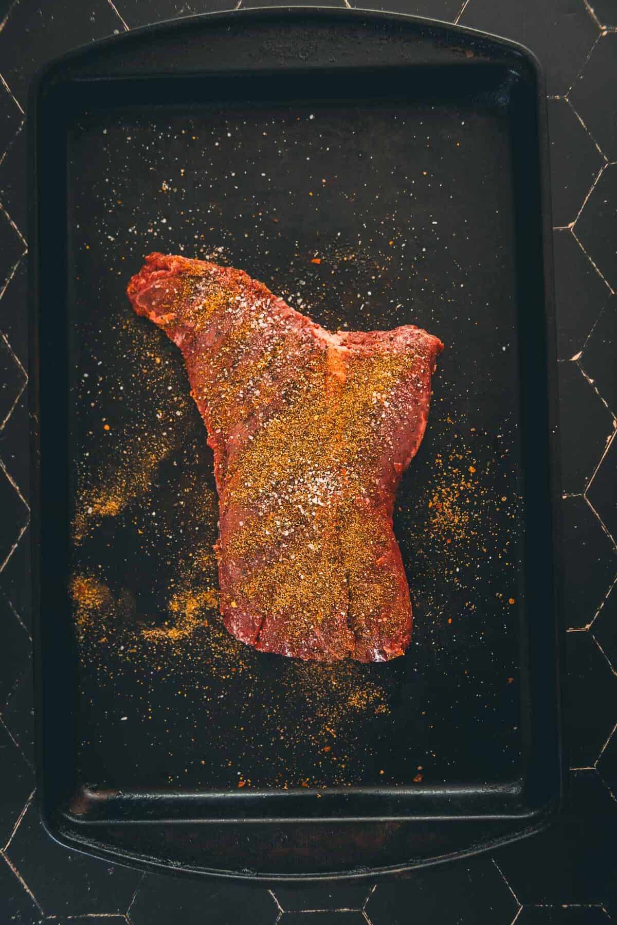 A piece of steak liberally seasoned.