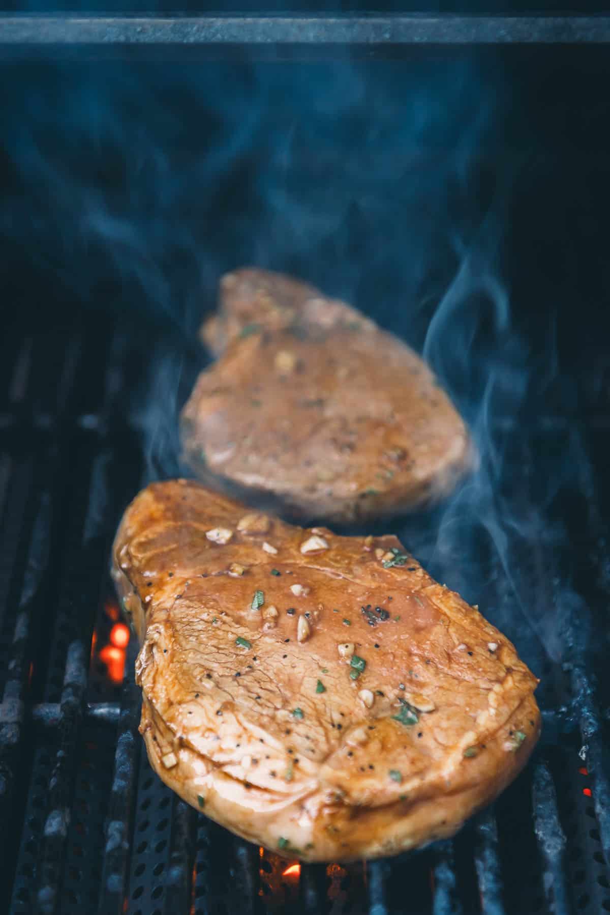 Pork chops on the grill grates.