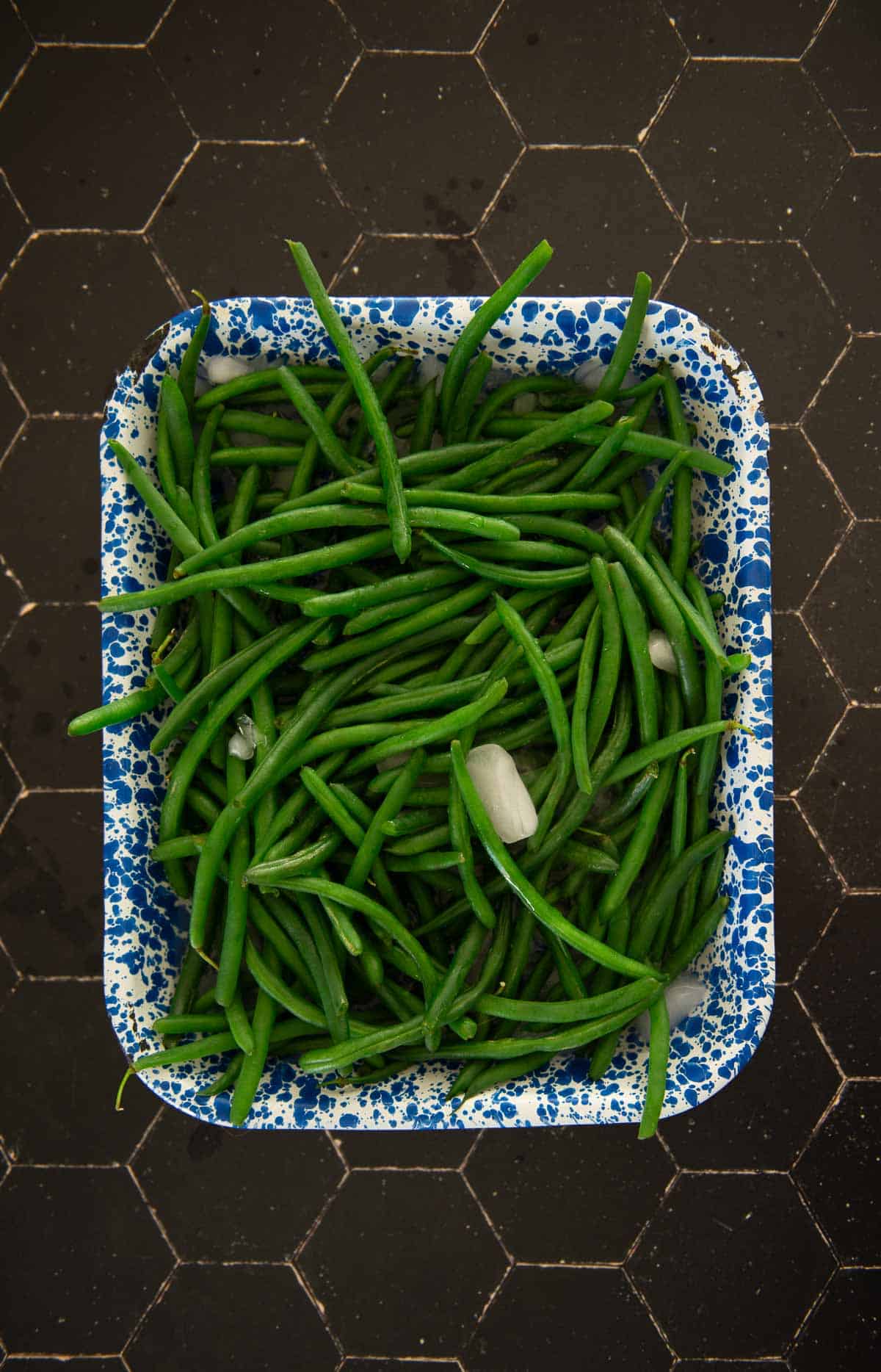 Green beans in a blue and white bowl.