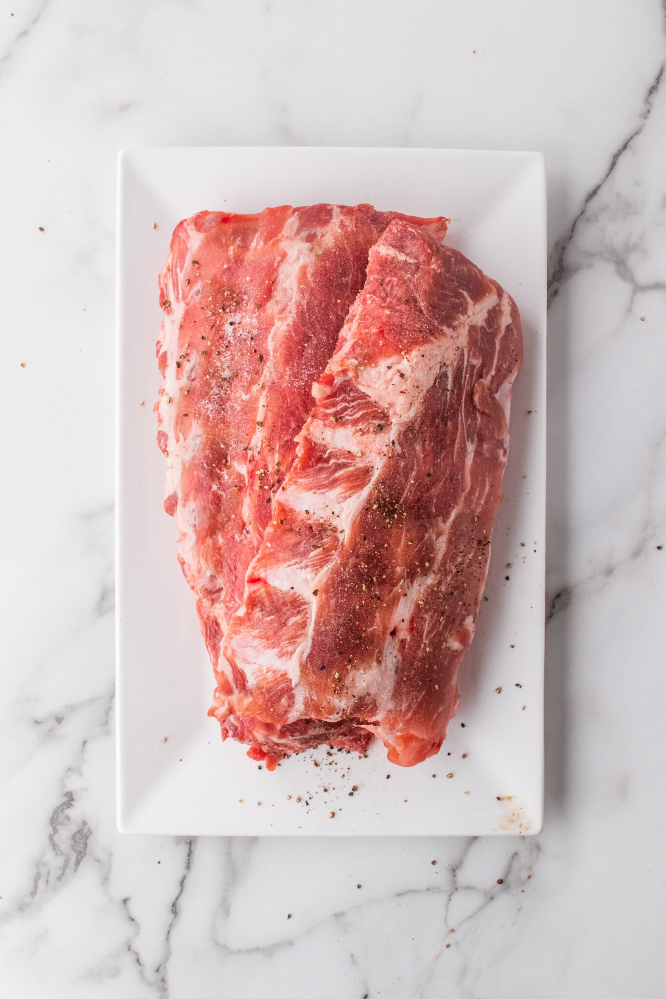 Baby back ribs on white plate.