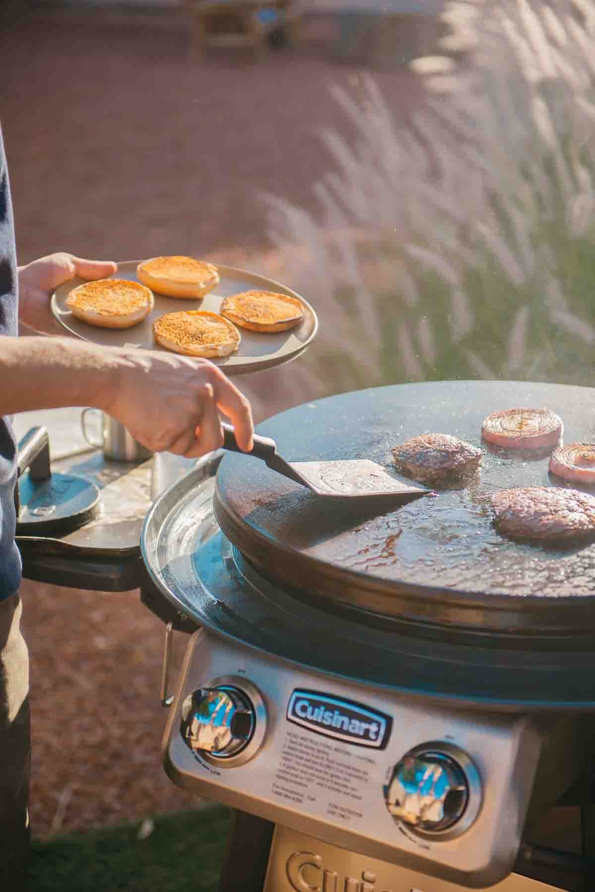 Burgers, onions and toasted buns coming off the griddle.