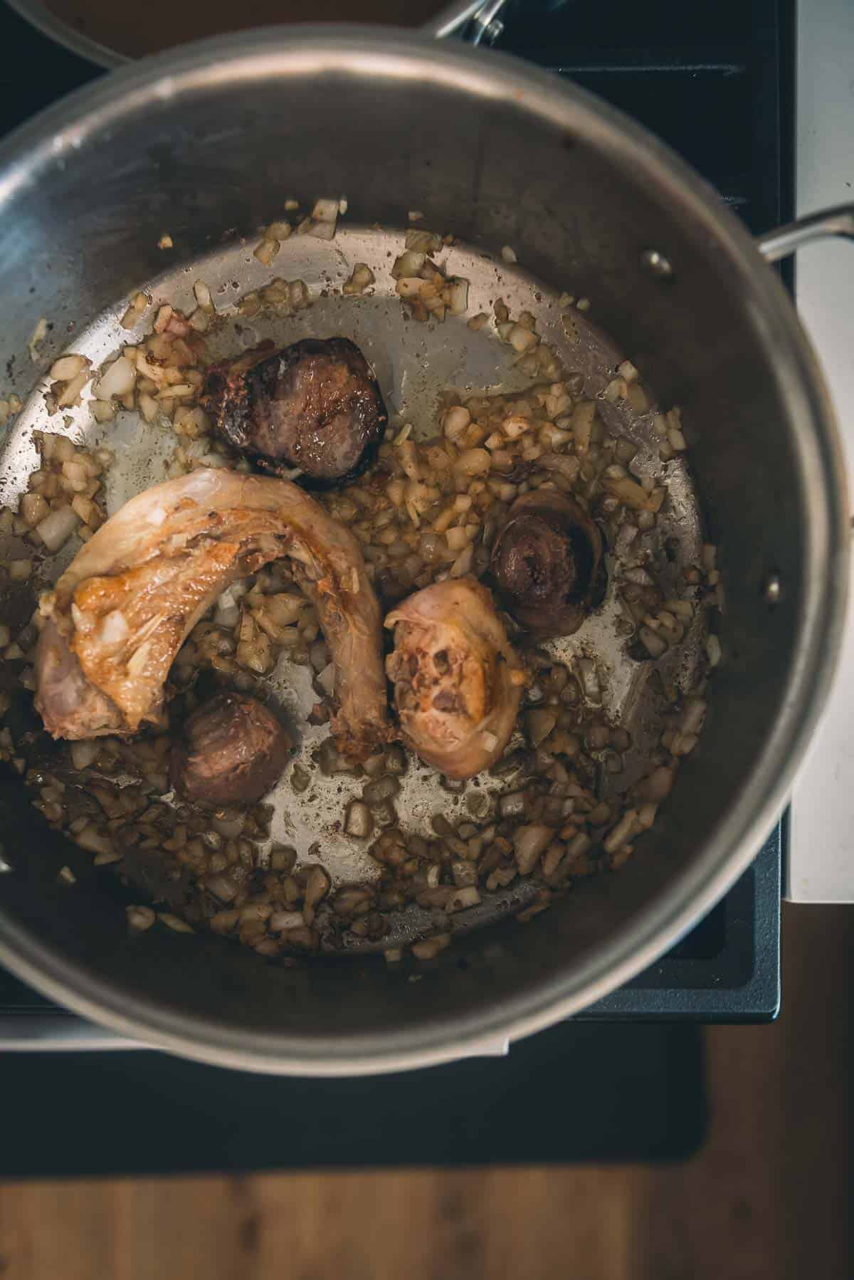Turkey neck and giblets browning in a pot with onions.