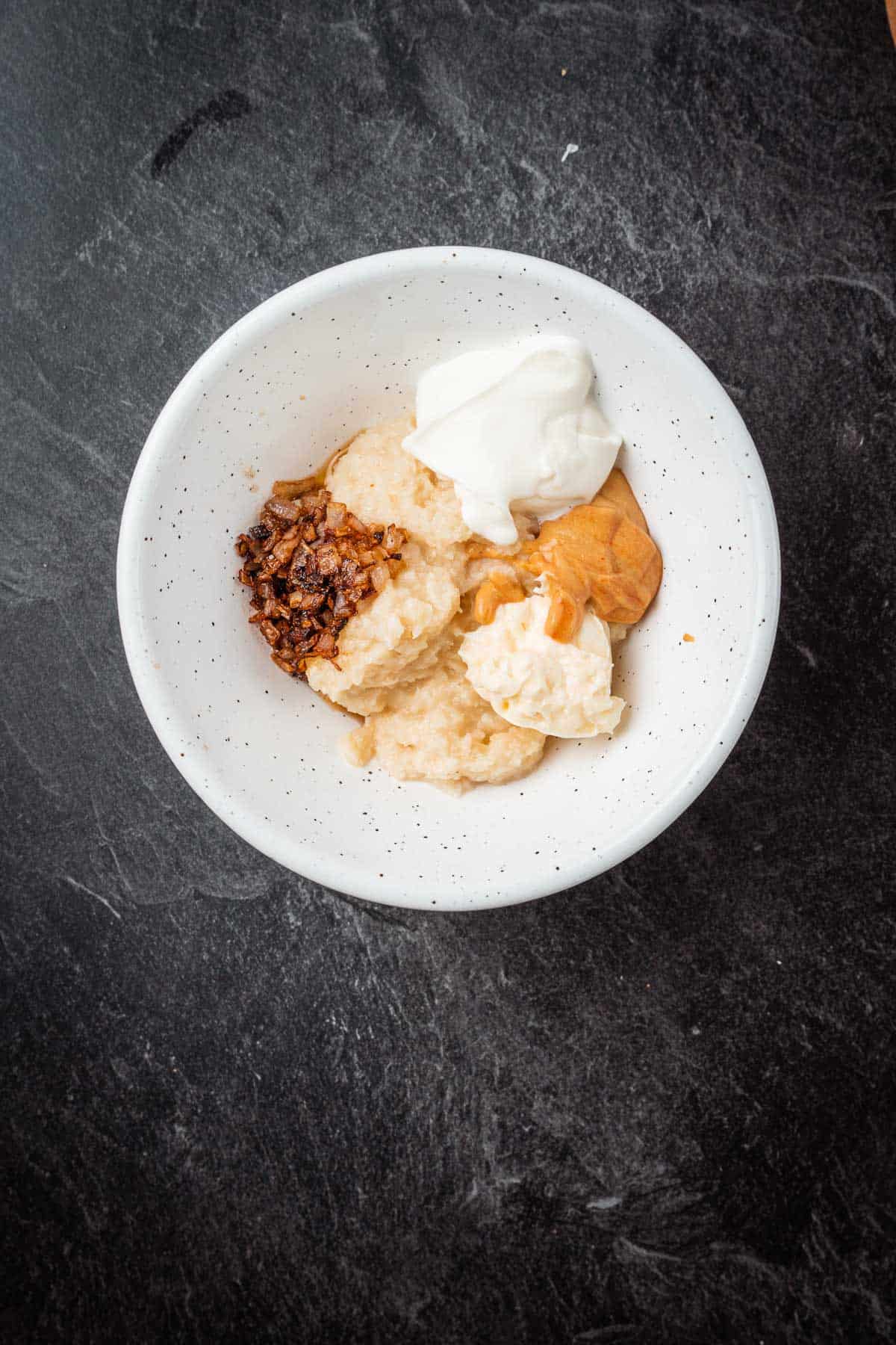 A white bowl with whipped cream and peanut butter.