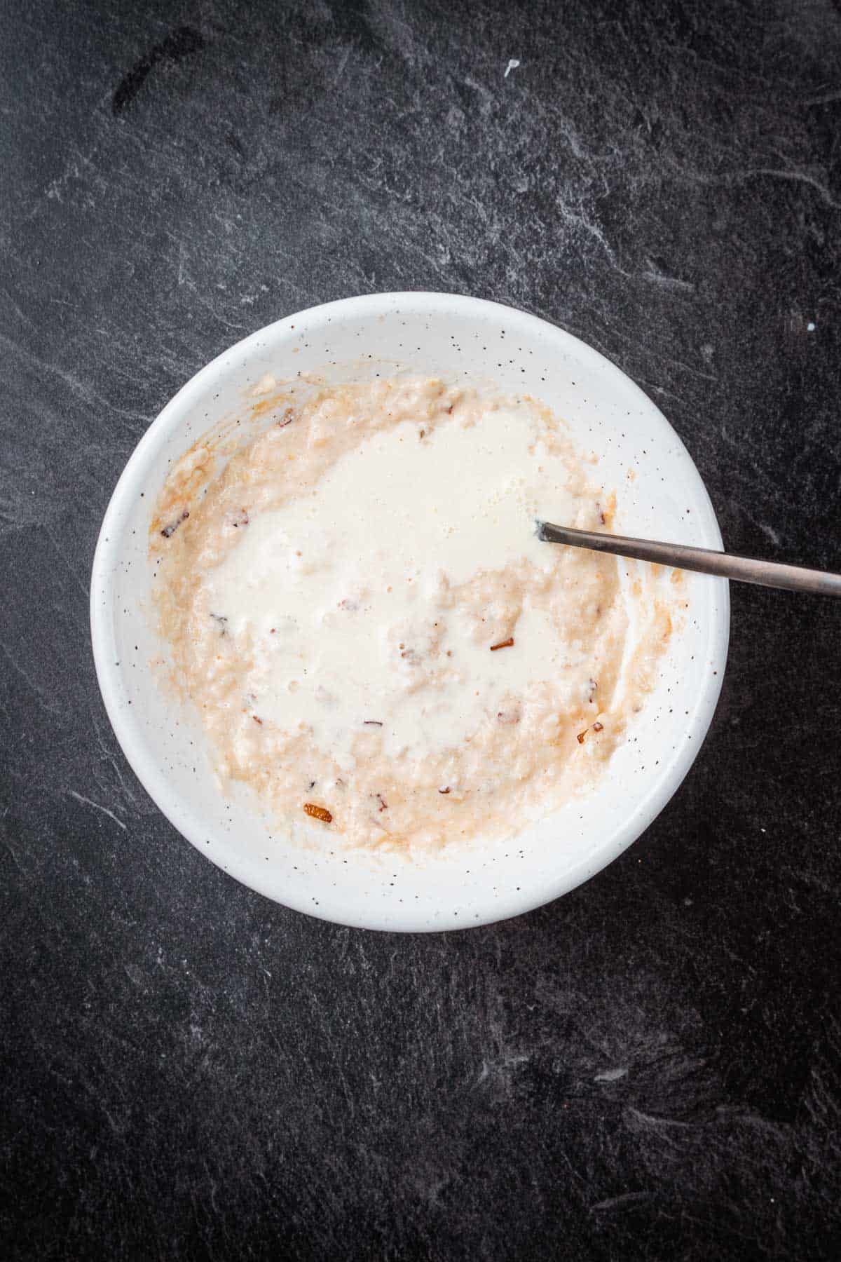 Oatmeal in a white bowl with a spoon.