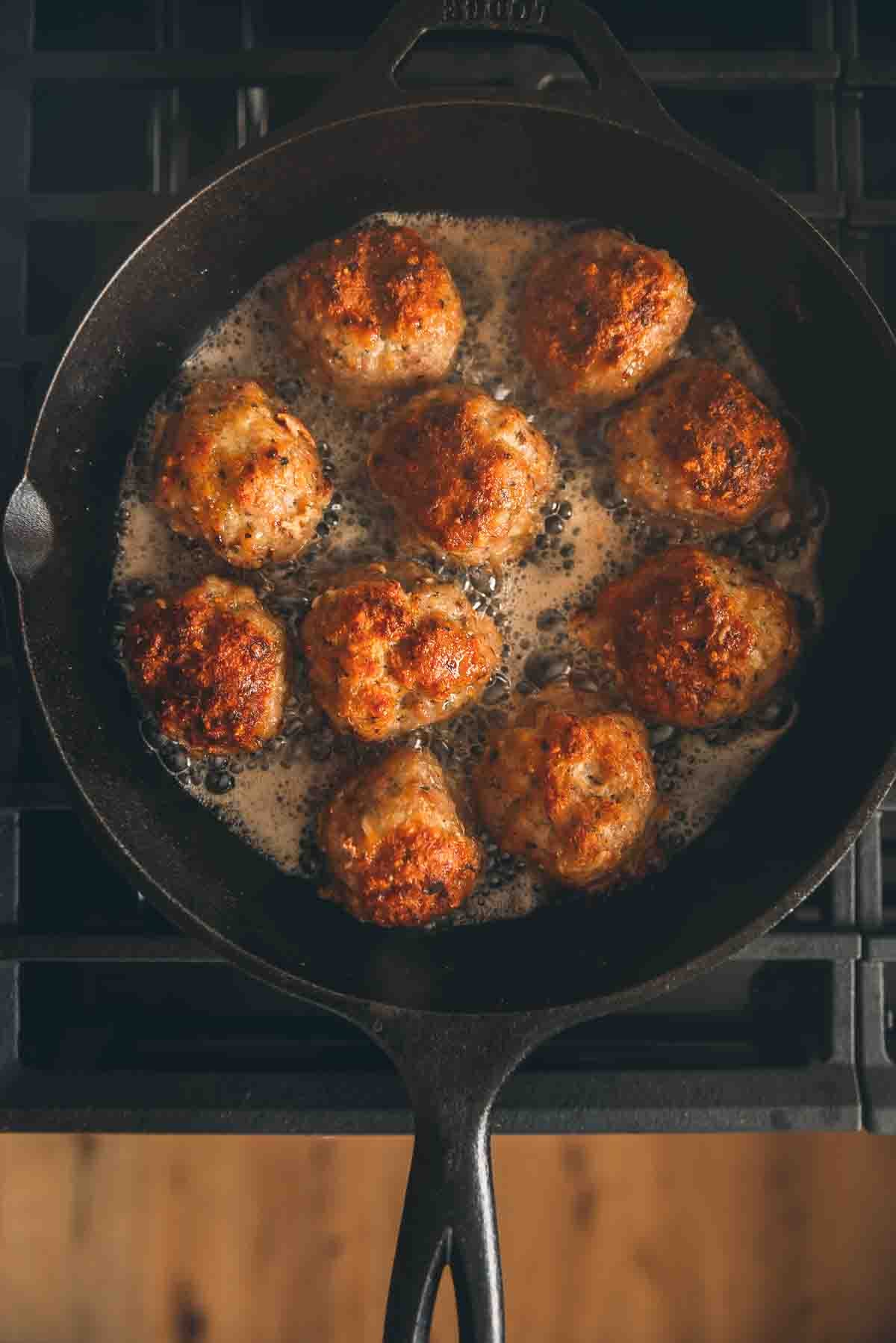 Cast iron skillet filled with meatballs.