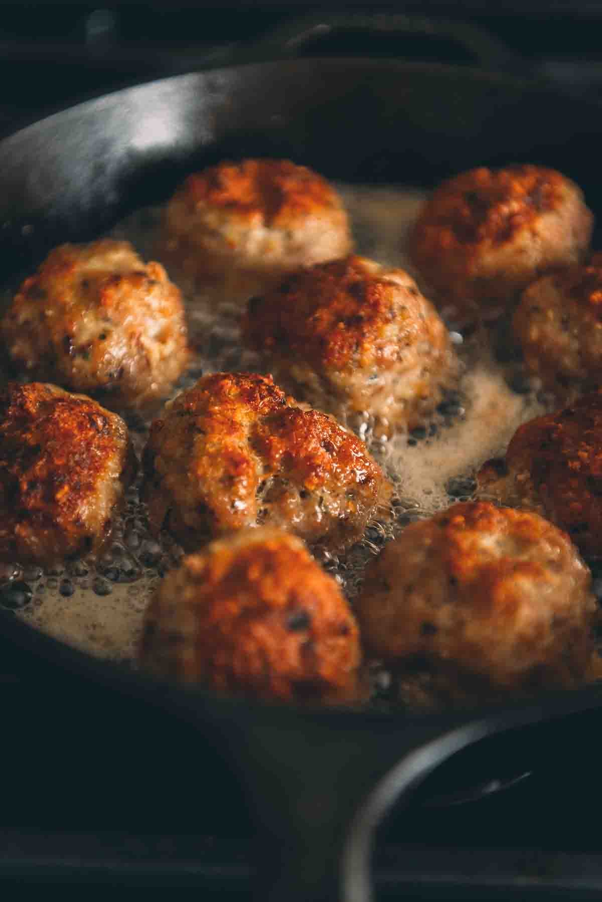 Close up of golden brown crust on top of fried meatball.