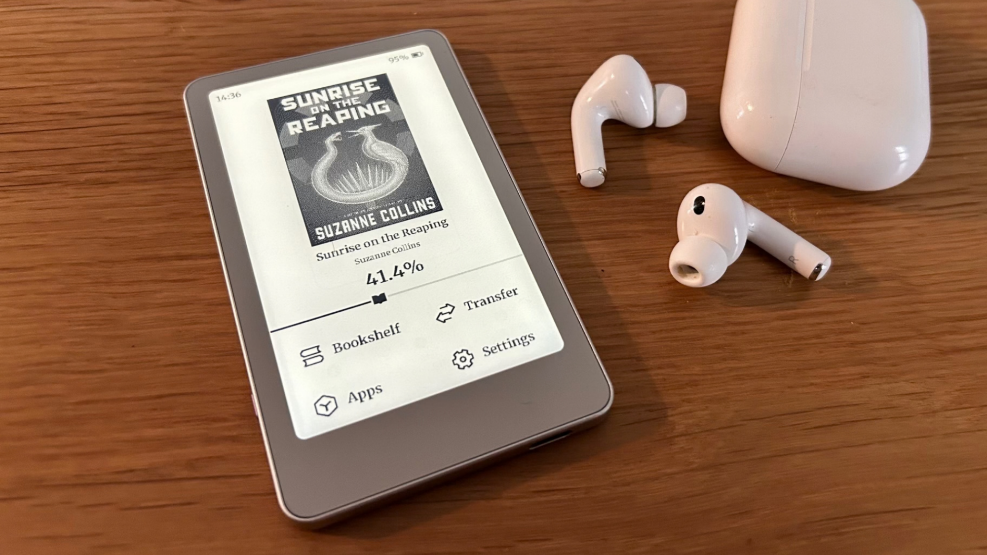 The Boox Picco on a table next to a pair of AirPods Pro 3 for scale