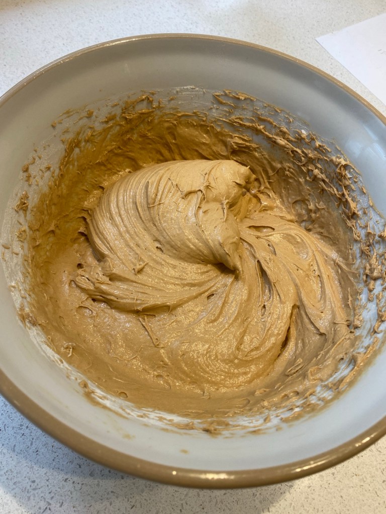 A mixing bowl with cup cake batter in
